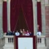 El papa León XIV saluda desde el balcón central de la Basílica de San Pedro, entre cortinas rojas
